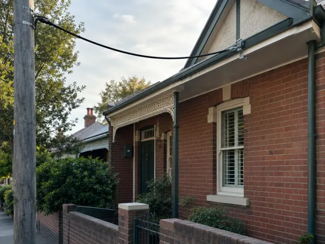 Brick house with a new overhead service cable and point-of-attachment bracket on the eaves in Wollstonecraft
